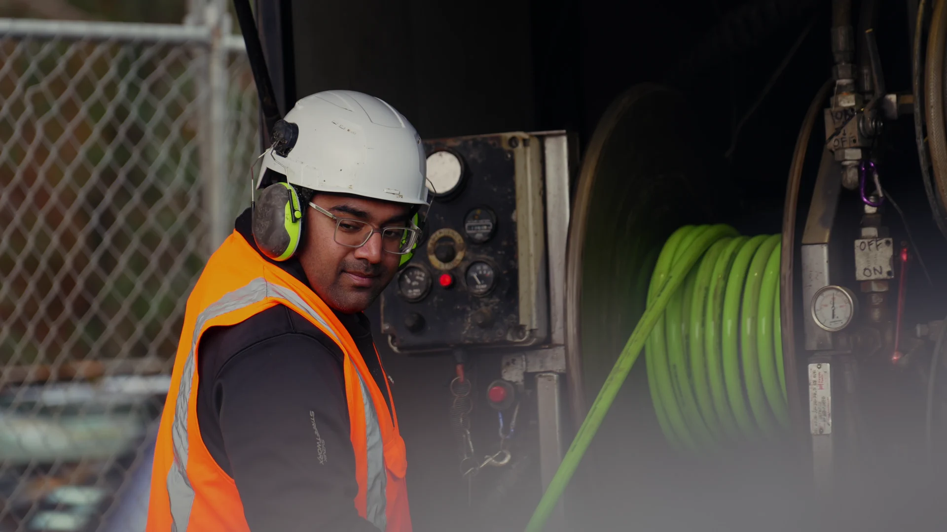 Operator at the truck's control panel beside the hose reel