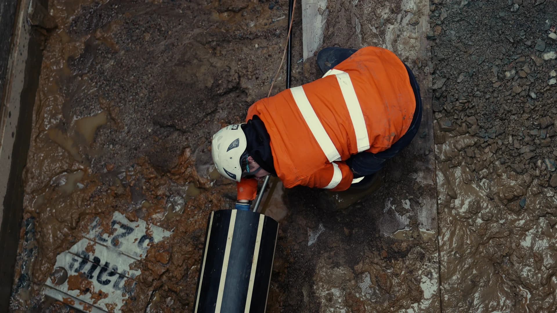 Daylighting: crew member at an exposed pipe in the dig